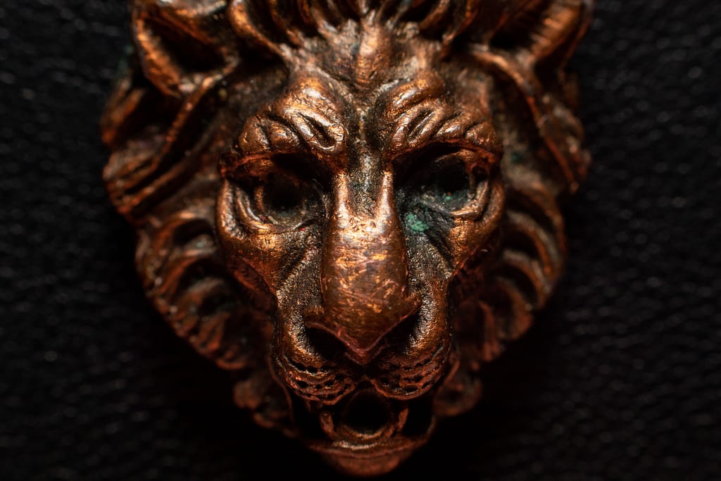 Macro photo of a small metal decorative piece in the shape of a lion